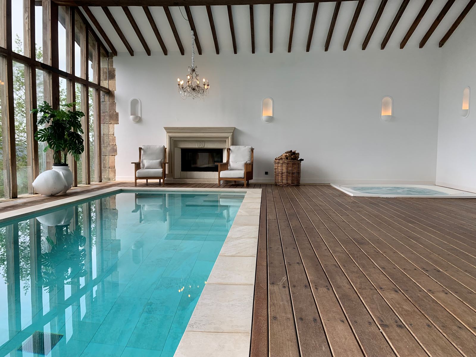 Piscine intérieure avec plage en bois et spa